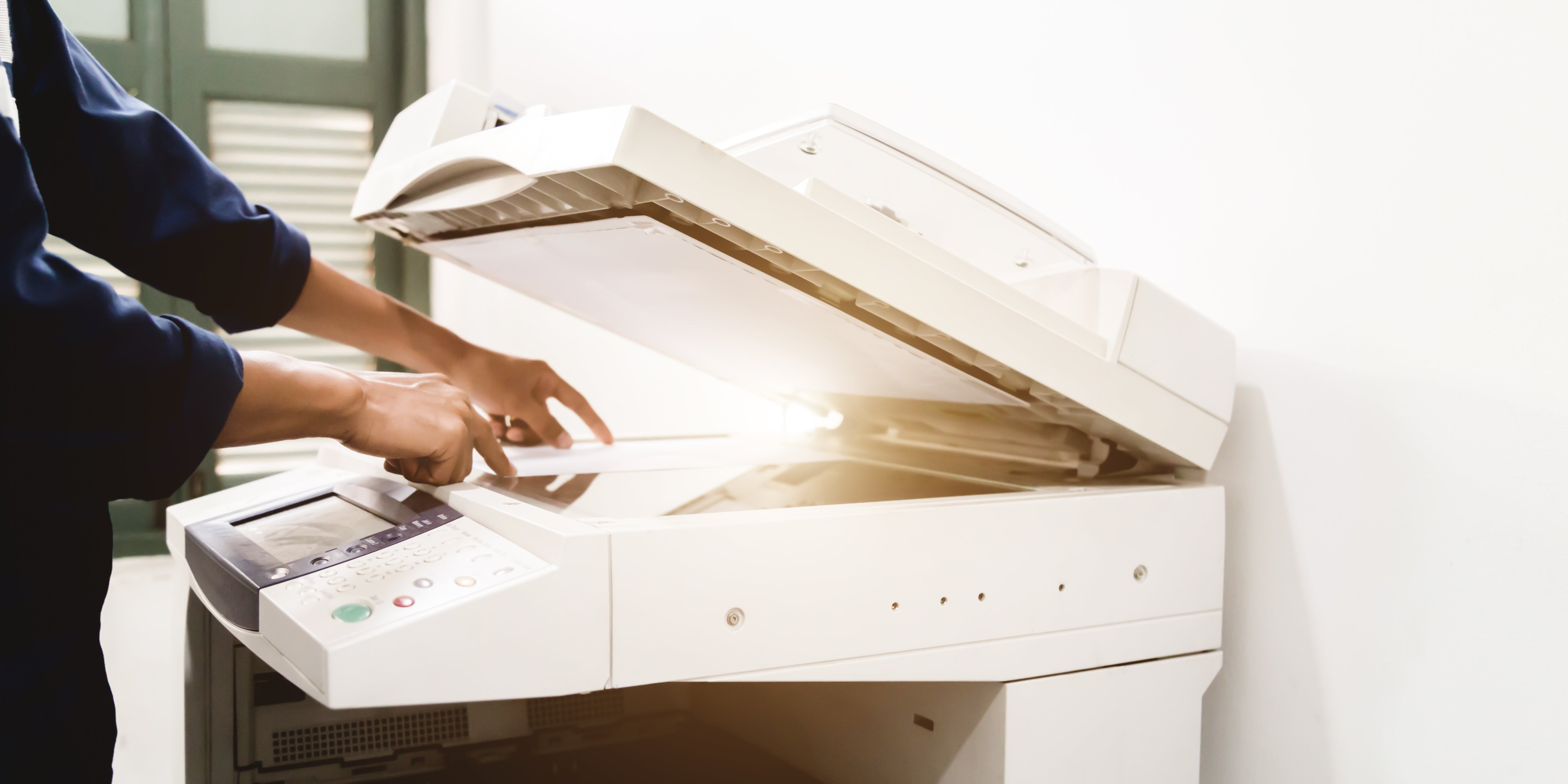 a person runs copies on a photocopy machine